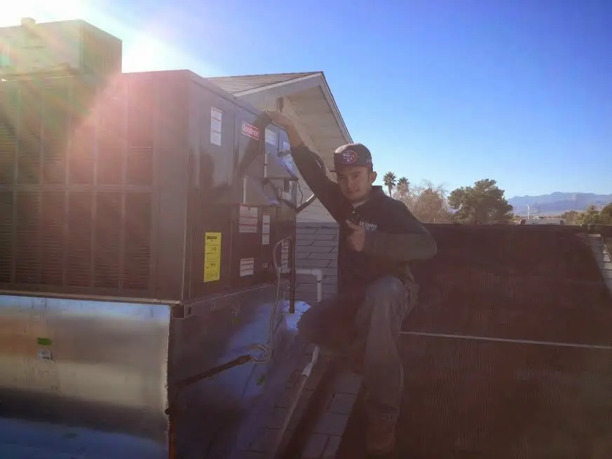 HVAC technician performing Boiler Repair on a rooftop unit in Cheyenne
